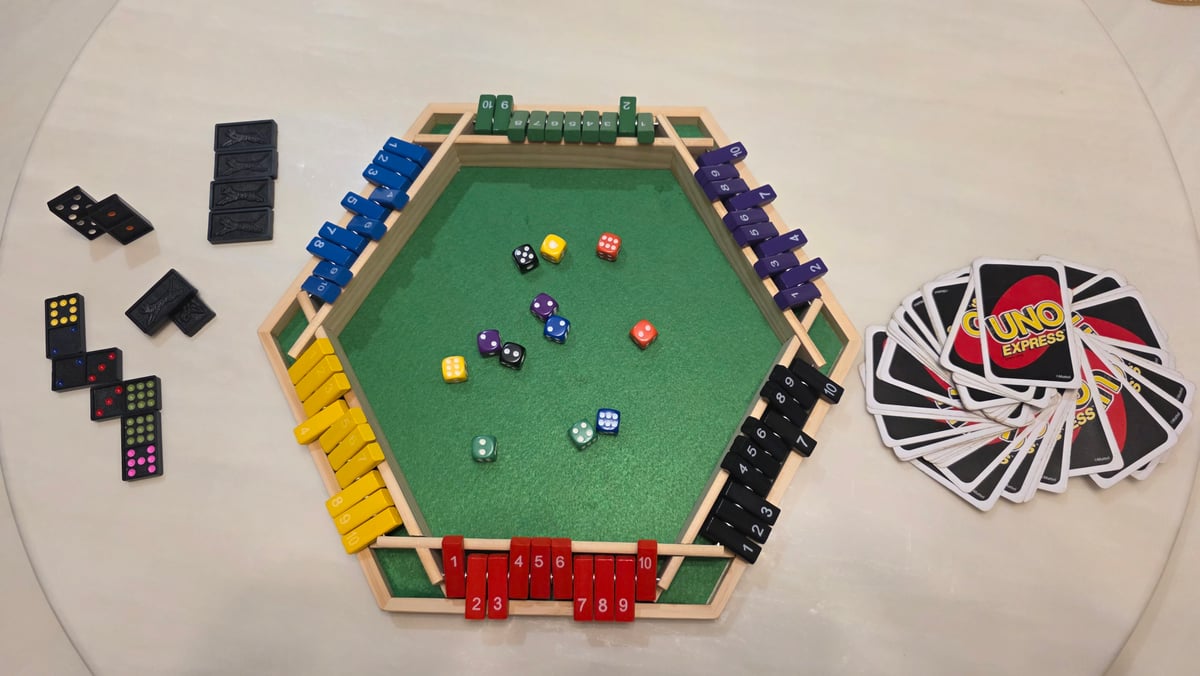 Dice, numbered tiles, dominoes and UNO cards laid out for the Dios board-game meetup