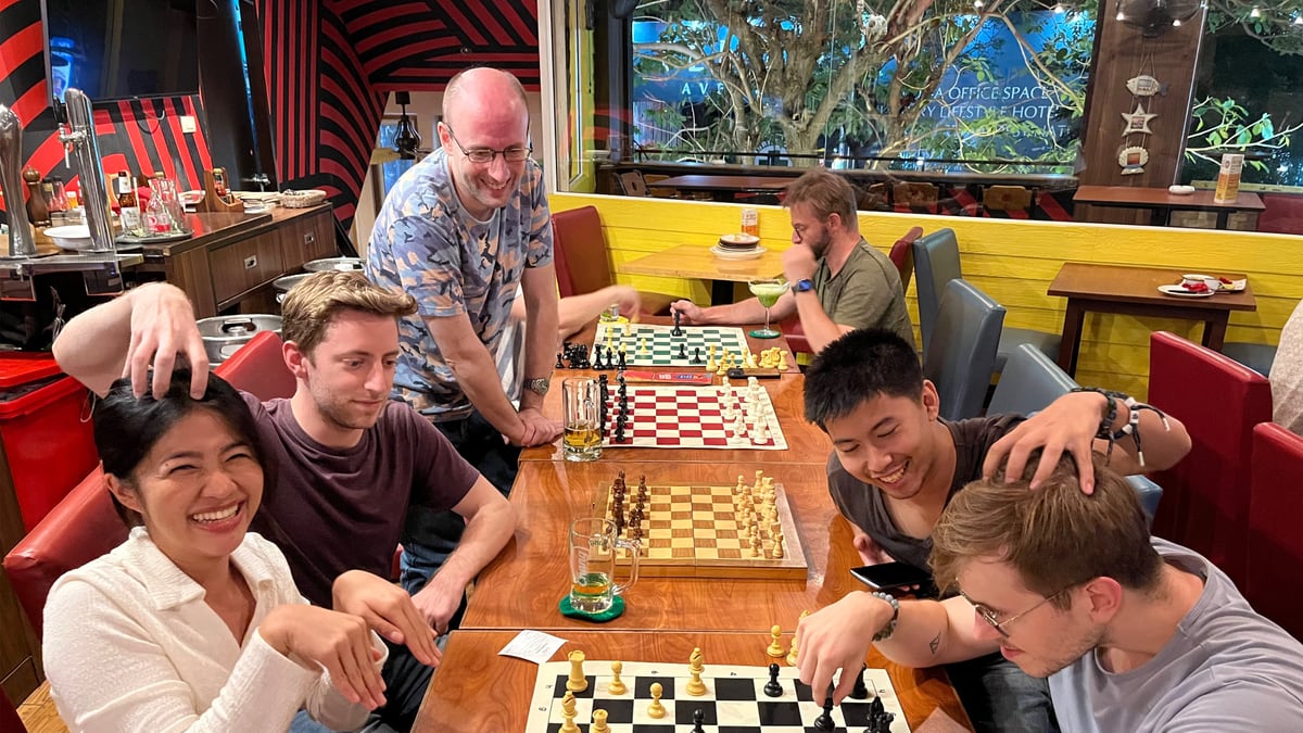 Players enjoying social chess together around a pub table in Bangkok