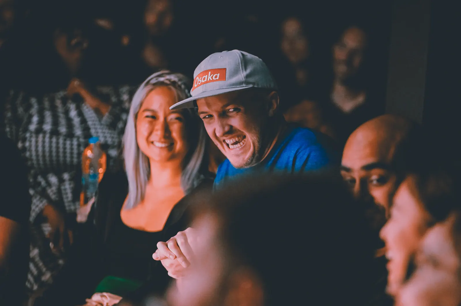 Audience members laughing together at a Bangkok comedy show