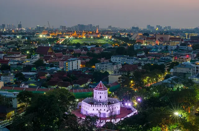 Phra Sumen Fort lit up at night with the Old Town behind it