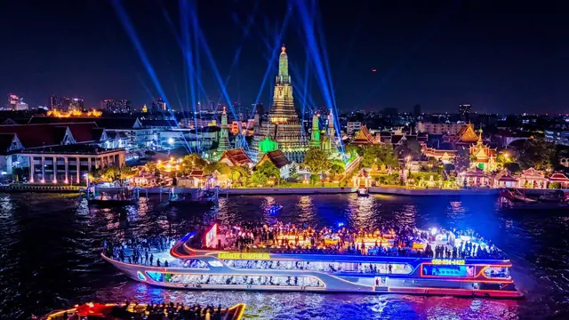 Vijit Chao Phraya in 2025, with a lit-up boat passing Wat Arun