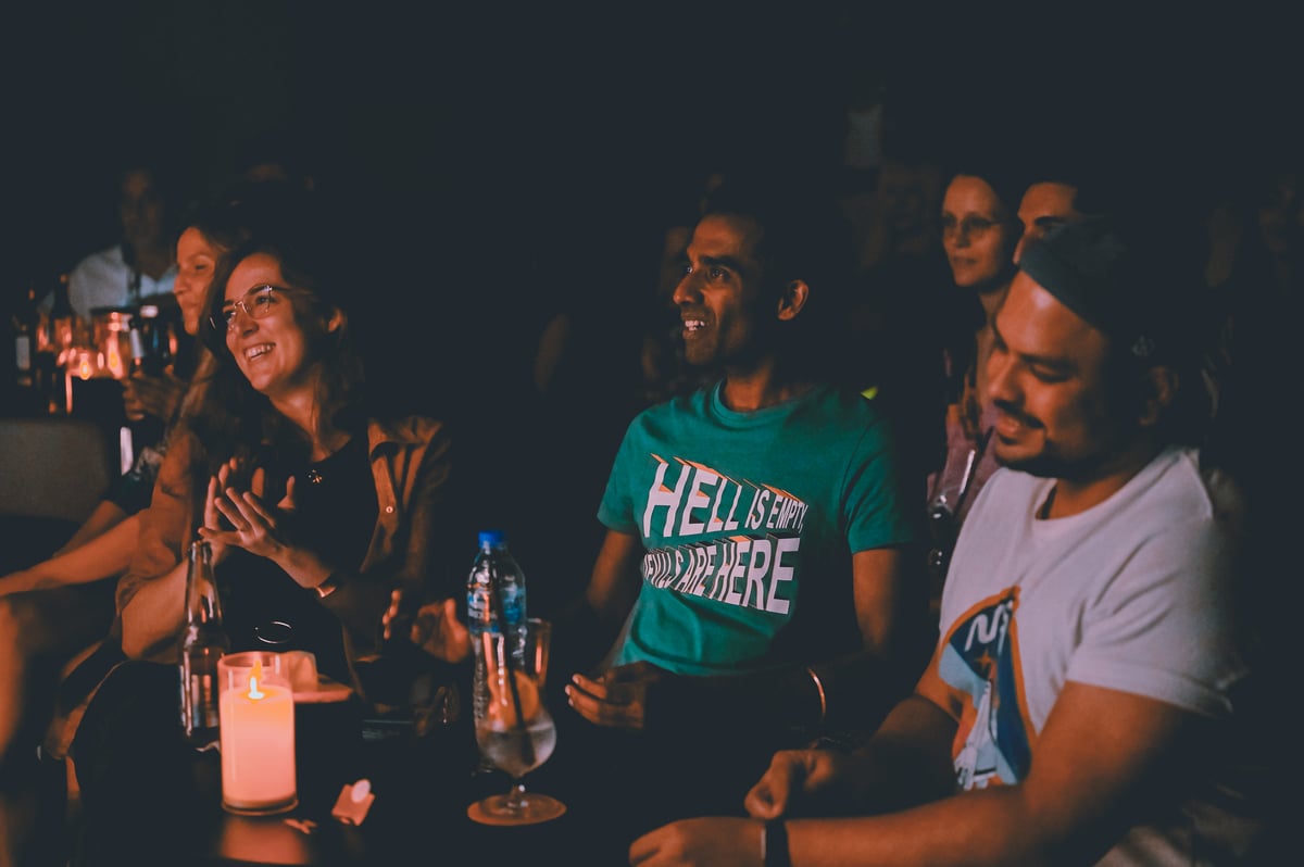 Audience members laughing together at a Bangkok stand-up show