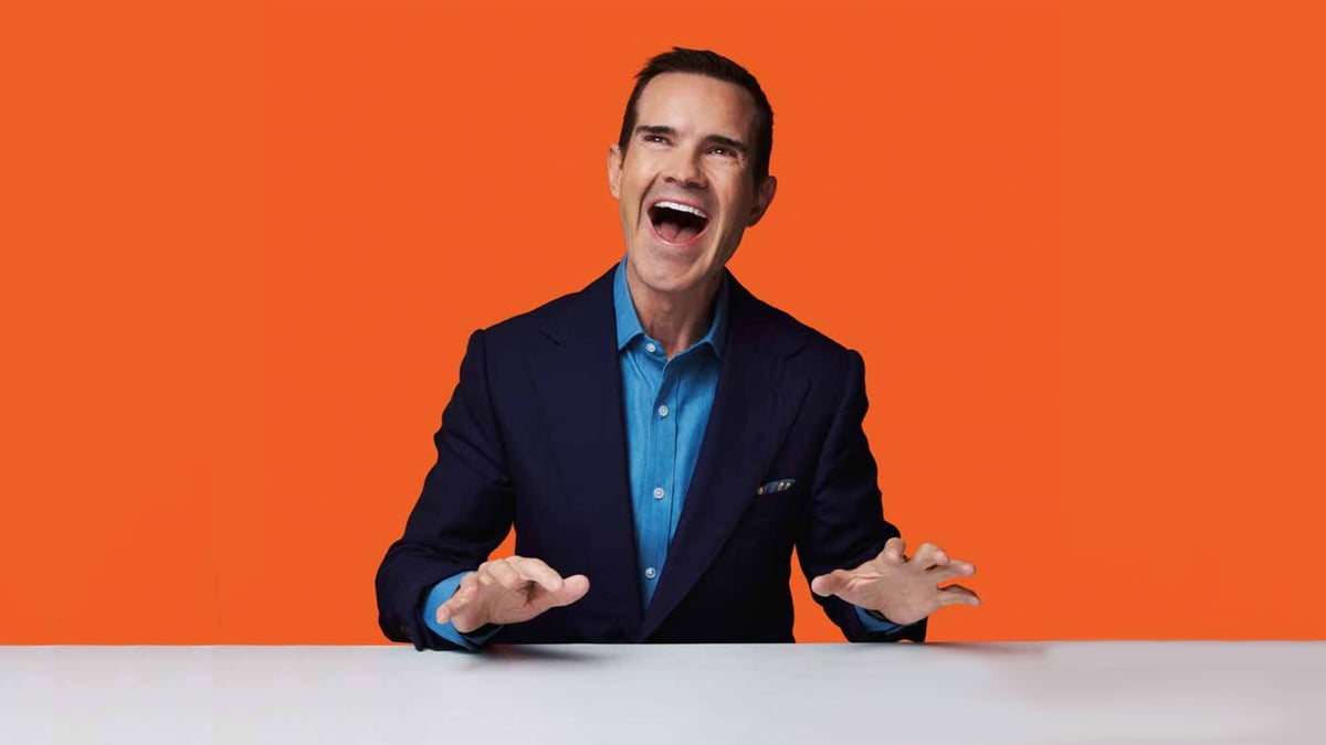 Jimmy Carr laughing at a desk