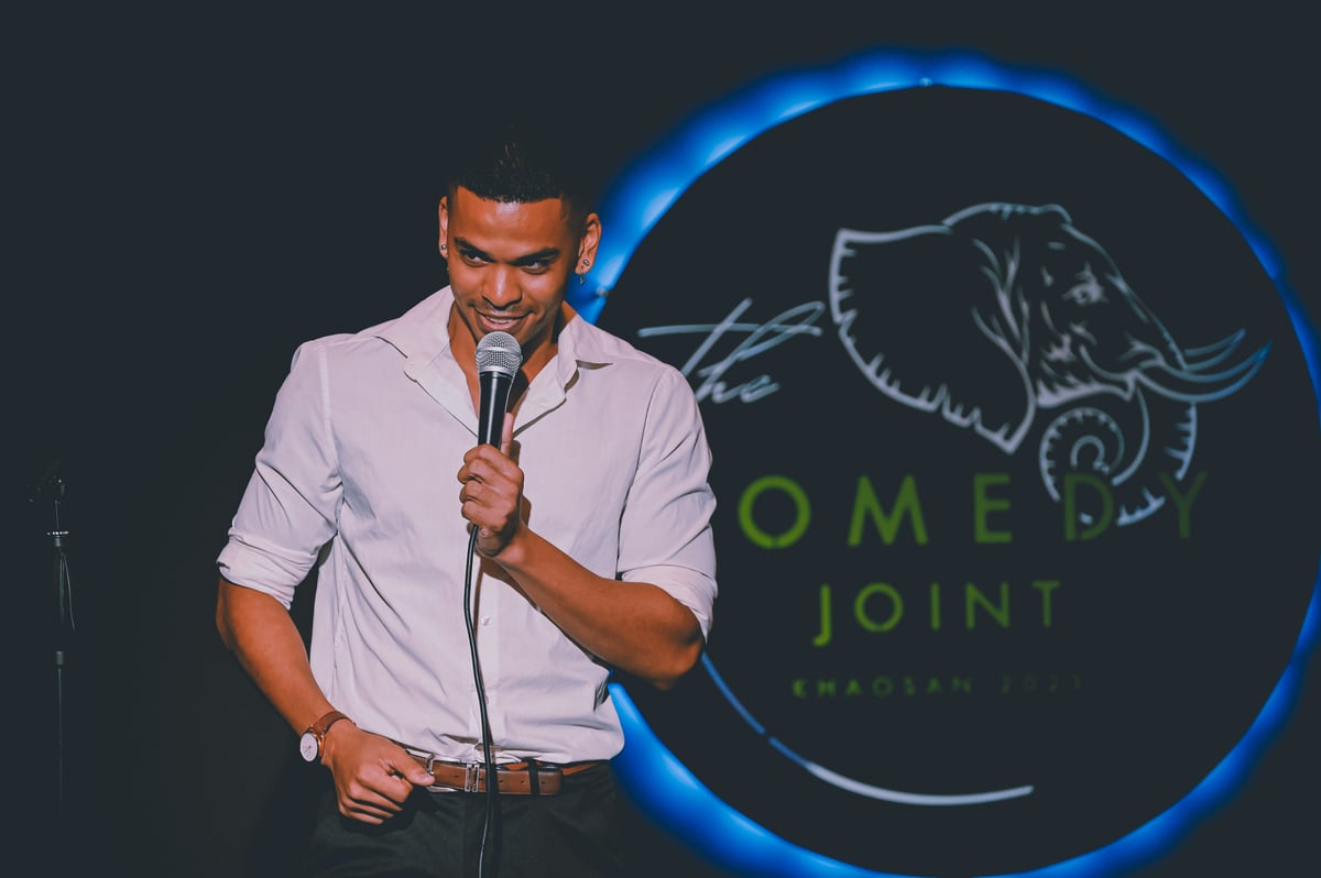 A comic speaking into a microphone at The Comedy Joint