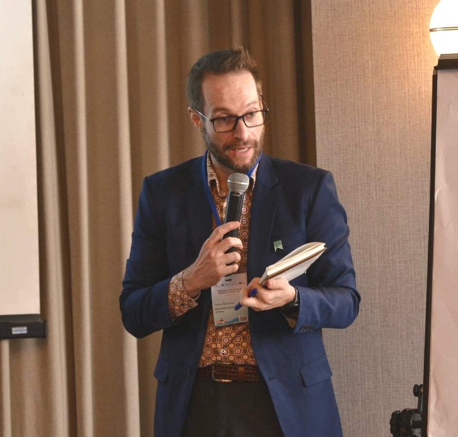 A host speaking into a microphone at a corporate event in Bangkok