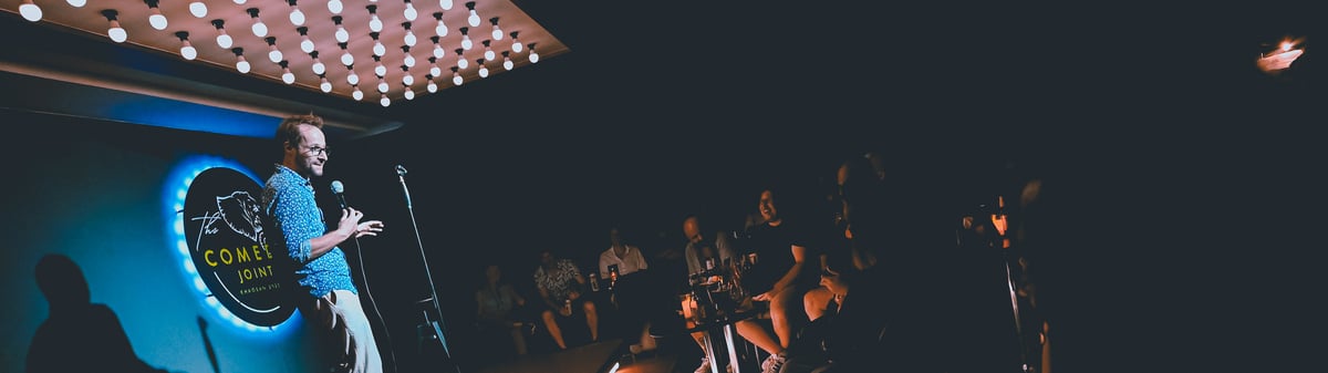 A comedian performing for the audience at The Comedy Joint