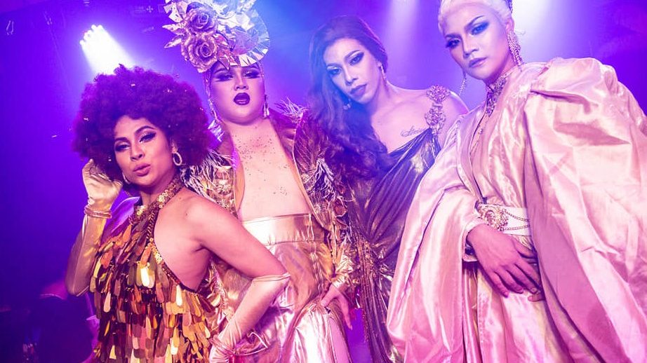 Four drag queens in sequins and headdresses at House of Heals