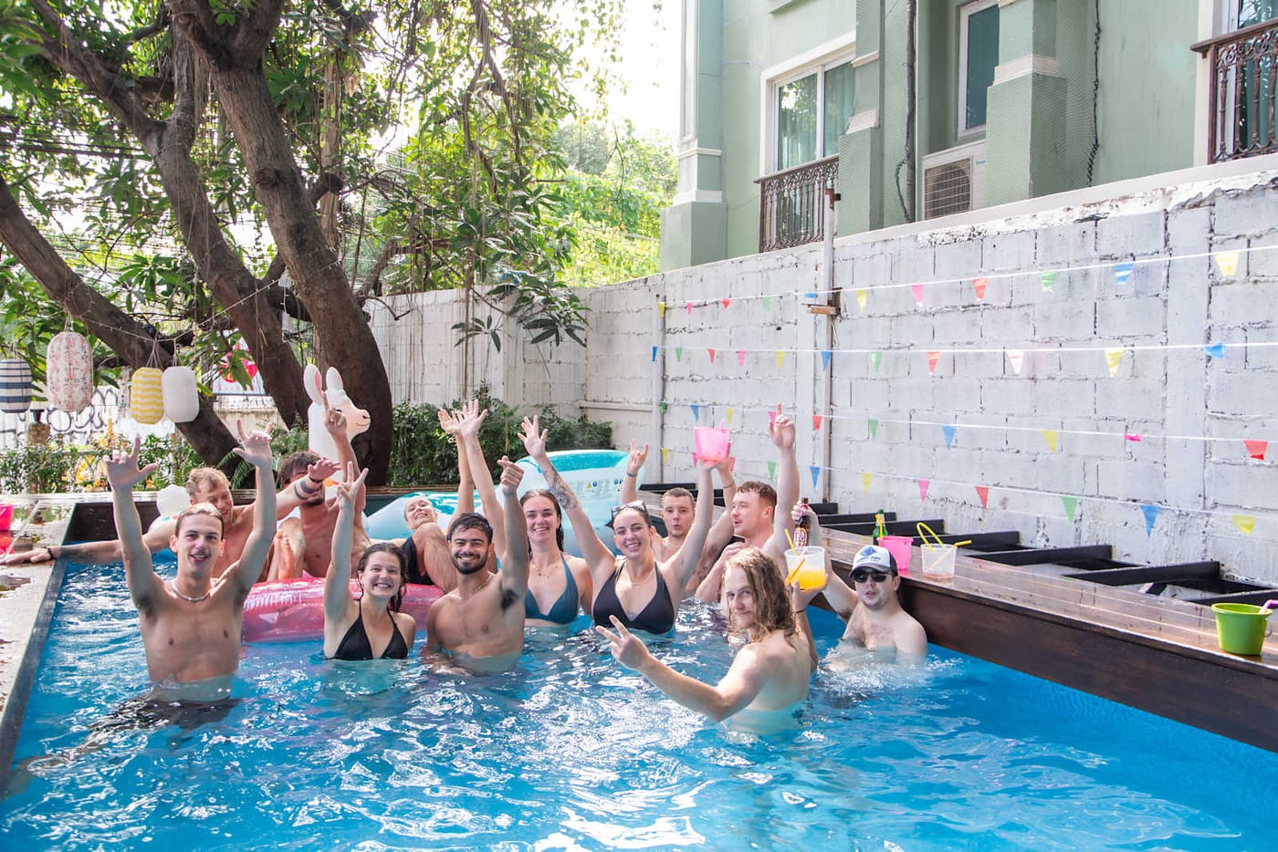 Guests in the pool at Revolution Khaosan by The Bliss, arms raised