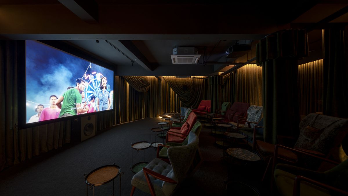 Armchairs and side tables facing the screen at Sala Saneha, a 25-seat cinema in Silom, with English subtitles on a Thai film