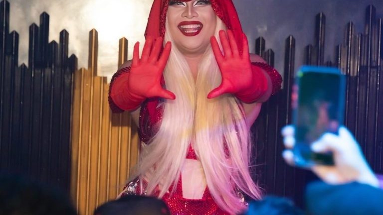 A drag queen in red performing at The Stranger Bar