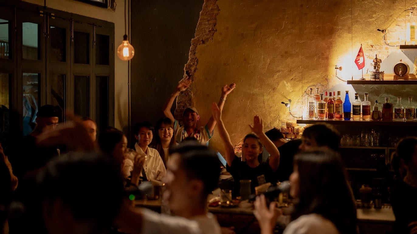Three musicians playing Thai instruments against a brick wall at Tep Bar