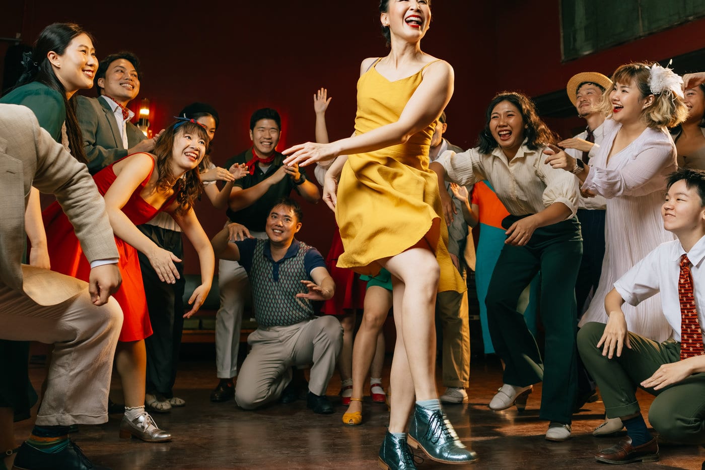 A full floor of swing dancers at The Hop in Silom, one dancer in a yellow dress mid-step